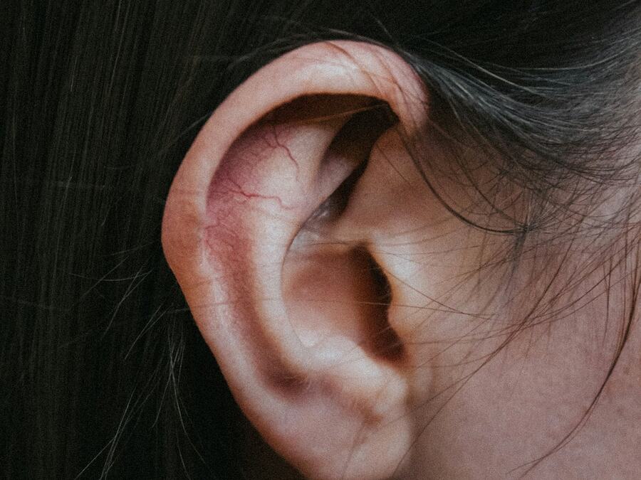 Grande plano de uma orelha, onde se estimulam os pontos da auriculoterapia