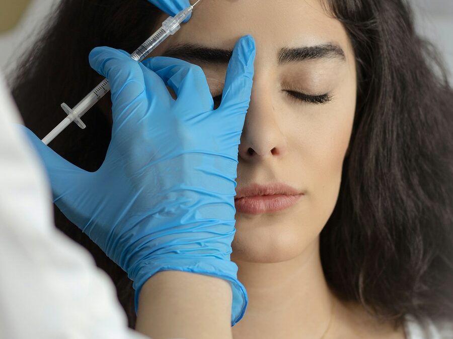 Aplicação de botox na testa de uma mulher de olhos fechados